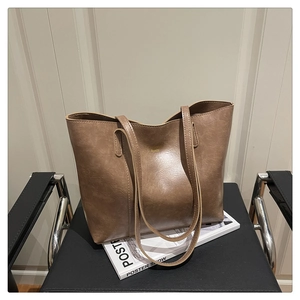 Détail du grand sac cabas en similicuir marron avec fines anses et lettrage doré chic