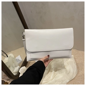 Detail view of the elegant white leather bag with fine stitching and silver hardware hooks
