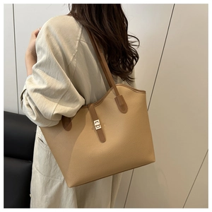 Detail of lychee pattern leather tote bag with brown straps and golden metal lock