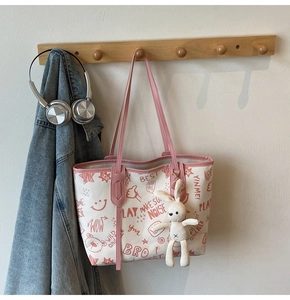 Detail of color-block tote bag with cute graffiti prints and white rabbit plush pendant
