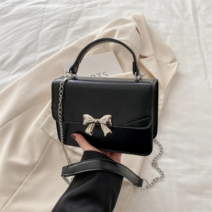 Fashionable black crossbody bag with silver bow detail and metal chain strap