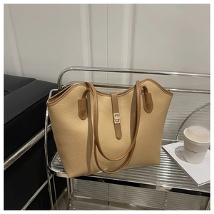 Detailed close-up of litchi grain leather tote bag with elegant golden metal buckle