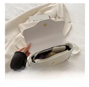 Vue de dessus de l'intérieur d'un sac à main blanc croco montrant sa grande capacité