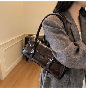 Detail of dark brown oil-wax leather shoulder bag with vertical quilting and double straps