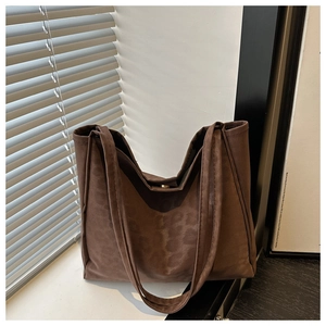 Detail showing the subtle leopard print texture on the brown faux suede tote bag surface