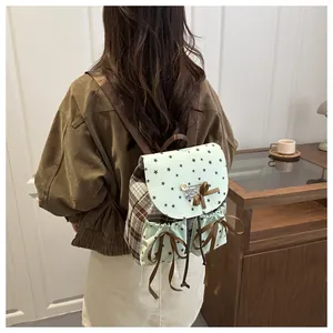 Detail showing mint green and brown plaid backpack with star print and bow accents