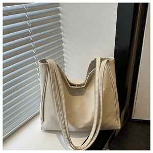 Detailed view of cream faux leather tote bag with magnetic closure and soft shadow