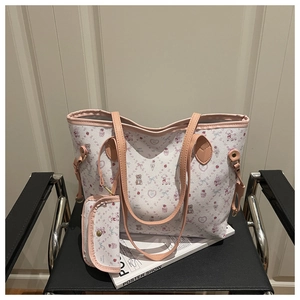 Détail du grand cabas blanc à motifs d'ours roses avec sa pochette assortie sur une chaise
