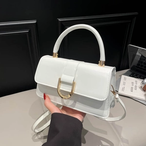 Elegant white crossbody bag with golden D-buckle and top handle for professional women