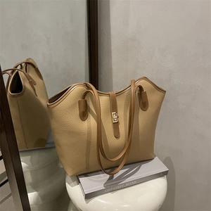 Minimalist apricot pebbled leather tote bag with gold twist lock and dual shoulder straps