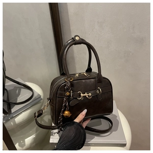 Detailed view of vintage dark brown crossbody bag with gold horsebit and oil wax finish