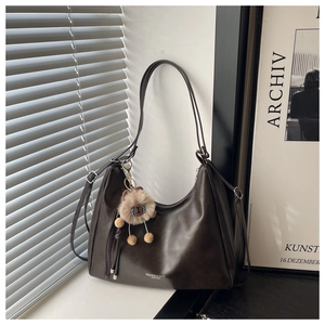 Dettaglio della borsa hobo vintage marrone scuro con ciondolo in peluche