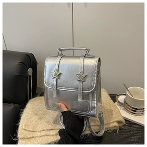 Detail of silver metallic PU mini backpack with star buckle and flap design