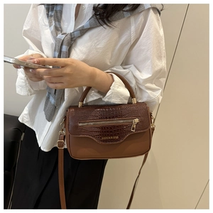 Sac à bandoulière marron motif crocodile sur mannequin avec zip doré chic