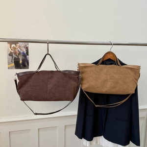 Detail of vintage suede tote bags in brown and camel with adjustable straps and handles