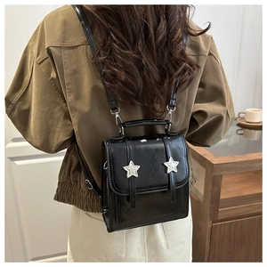 Détail du mini sac à dos noir brillant avec des motifs d'étoiles argentées sur le rabat
