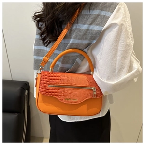 Détail de la texture cuir PU orange avec motif crocodile et logo doré de mode