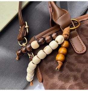 Dettaglio borsa retrò leopardata con perline di legno e texture in pelle scamosciata