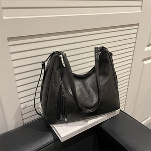 Borsa hobo retrò in pelle nera capiente con dettaglio cerniera e nappe decorative