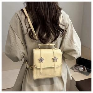 Close-up of a stylish cream mini backpack featuring star accents and adjustable straps