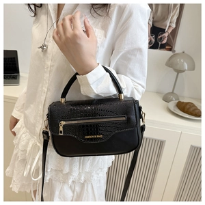 Détail du sac à bandoulière noir avec rabat croco et fermeture éclair en métal doré