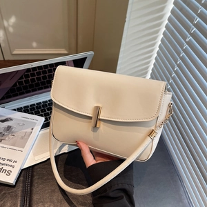 Minimalist beige leather shoulder bag with gold metal lock and long strap for women