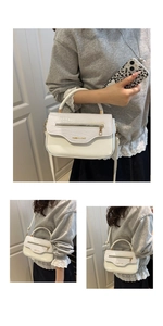 Vue détaillée du rabat blanc motif crocodile avec fermeture éclair dorée sur le sac