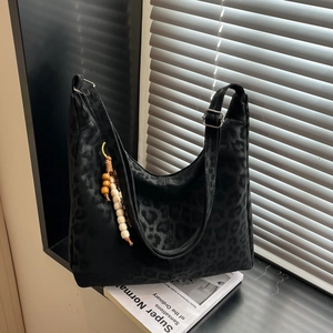 Large leopard print suede hobo bag with adjustable strap and beaded tassel detail