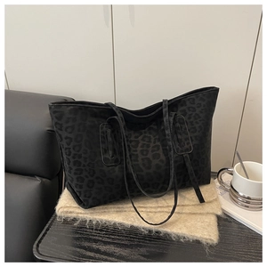 Detail of black leopard print tote bag with soft texture and slim double handles