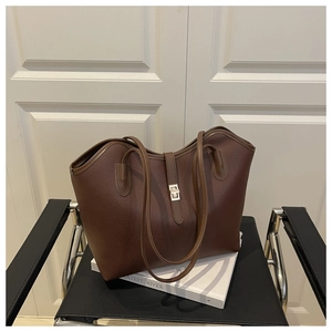 Detail of dark brown lychee pattern leather tote bag with elegant metal twist lock closure