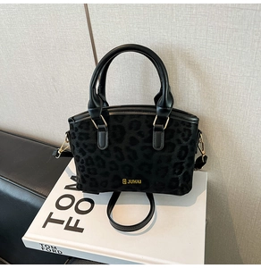 Dettaglio della trama leopardata su una borsa a tracolla con logo in metallo