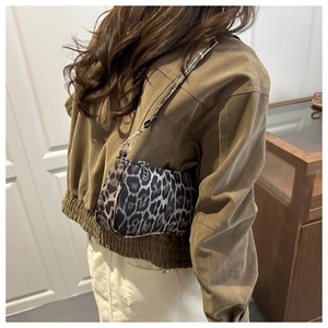Close-up of leopard print underarm bag with sleek leather texture and slim shoulder strap