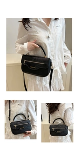Détail du sac à bandoulière noir motif crocodile avec fermeture éclair et poignées rondes
