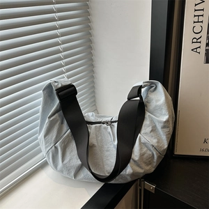 Light blue nylon crescent bag with pleated design and wide adjustable black strap