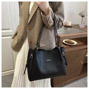 Close-up of minimalist black leather tote bag with subtle minimalist fashion text detail