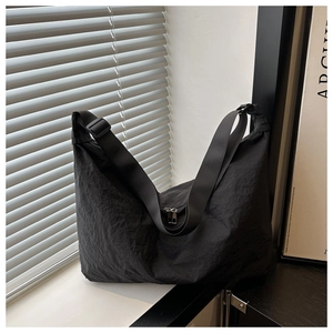 Detail of black nylon pillow bag showing high-density water-washed wrinkled fabric and strap
