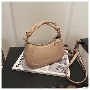 Detail of beige semi-circle handbag with knotted handle and elegant gold zipper