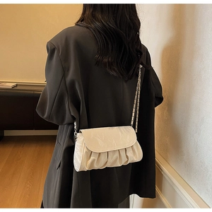 Detail of off-white pleated cloud bag showing silver chain strap and soft leather texture