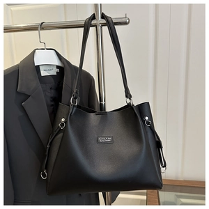Detail of black faux leather tote bag with Fashion & Bag logo and side drawstring design
