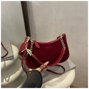 Détail du sac hobo bordeaux avec chaîne dorée et accessoire en forme de cerise
