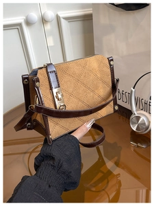 Détail des coutures en losanges et du fermoir rotatif en métal doré du sac à main vintage