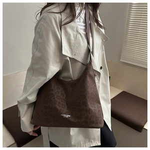 Macro detail of dark brown leopard print faux suede tote bag with white fashion text logo