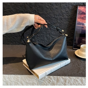 Minimalist black pebble leather hobo bag with knotted straps and gold hardware for women