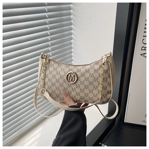 Détail du sac croissant beige avec imprimé monogramme M et logo doré métallique