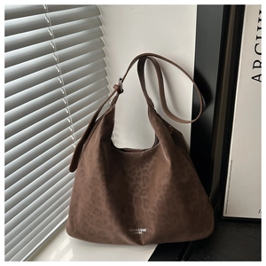 Detail of dark brown leopard embossed suede tote bag with adjustable silver buckle strap