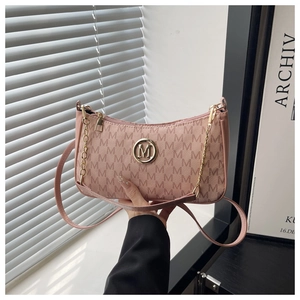 Détail du sac demi-lune rose avec imprimé de lettres et chaîne dorée élégante