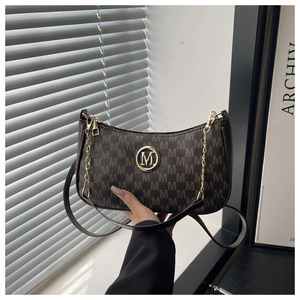 Détail du sac porté épaule vintage avec monogramme, logo M doré et bandoulière chaîne