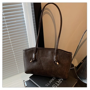 Detailed macro of the matte dark brown retro tote showing FASHION & BAGS embossing
