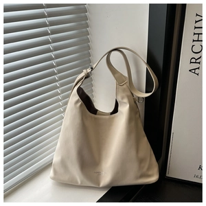 Detailed view of the creamy white faux leather tote bag with subtle logo text print