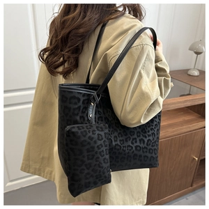 Leopard print velvet tote bag with matching inner pouch shown on shoulder in interior setting